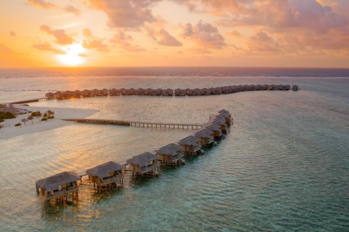 You & Me Cocoon Maldives overwater villas and lagoon at sunset