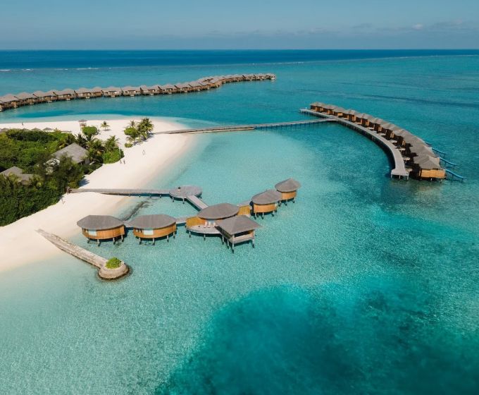 You & Me Cocoon Maldives aerial view with turquoise lagoon and overwater villas