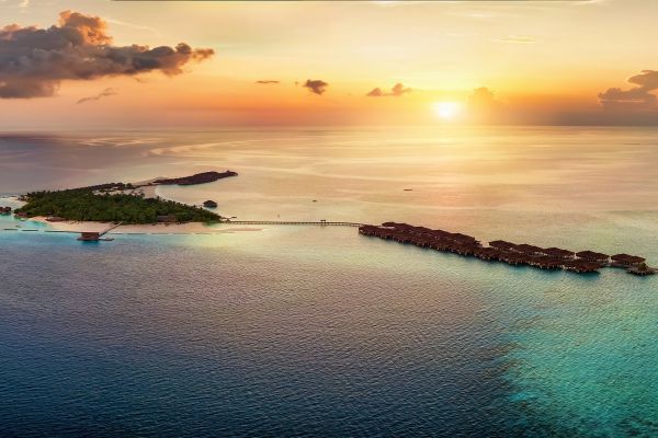 Luxury Maldives island with overwater villas at sunset for UK travellers