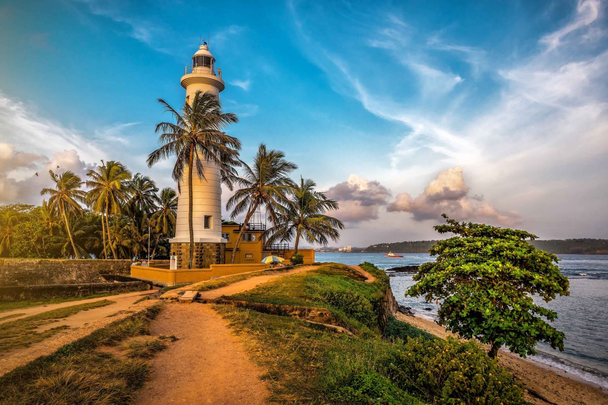 Historic lighthouse and tropical coastline in Galle, Sri Lanka