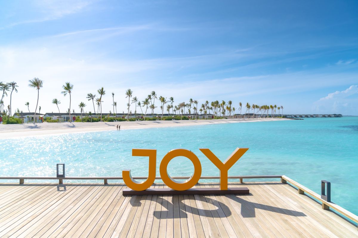 Joy Island Maldives welcome sign overlooking the turquoise lagoon